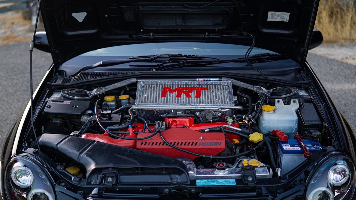 Mechanic inspecting engine on Japanese vehicle in repair shop